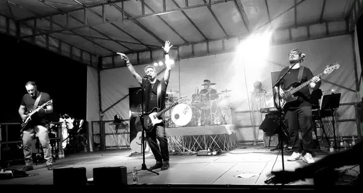 I Souvenirs al completo sul palco, in bianco e nero, con il cantante a braccia alzate