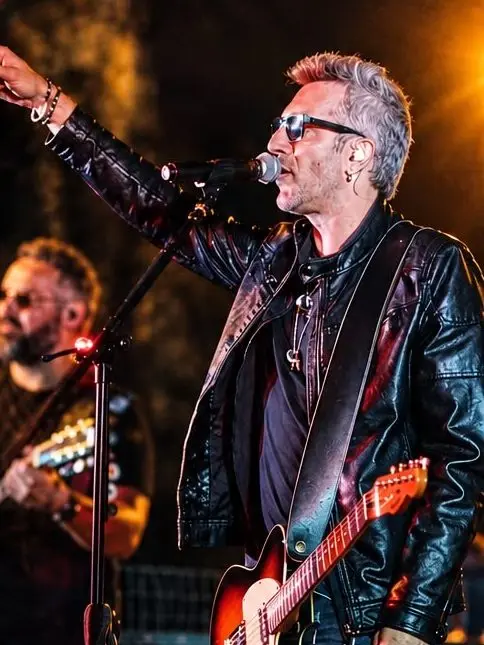Nazareno Albanesi, voce dei Souvenirs, sul palco in giacca di pelle con la chitarra